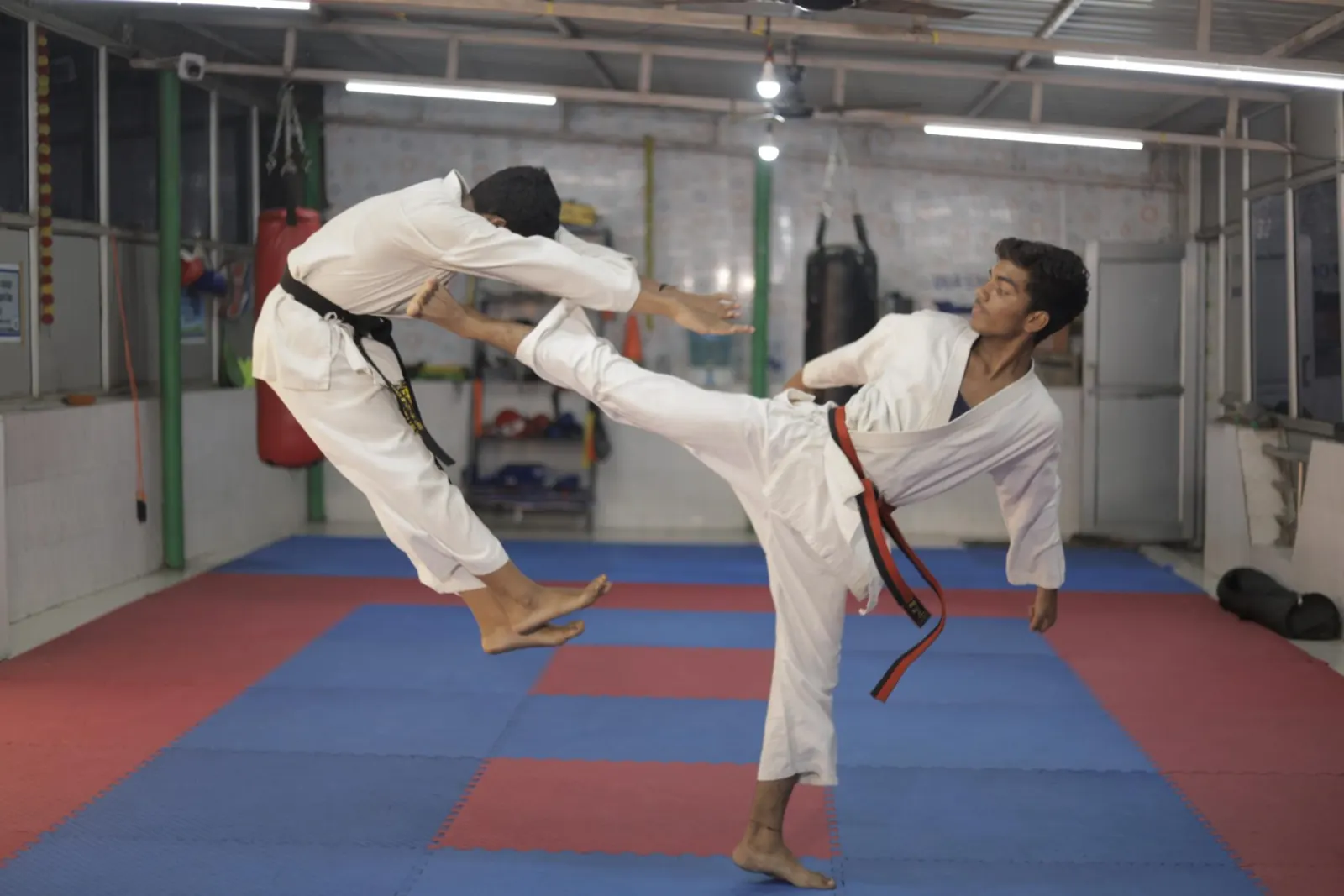 Two students sparring with a high kick